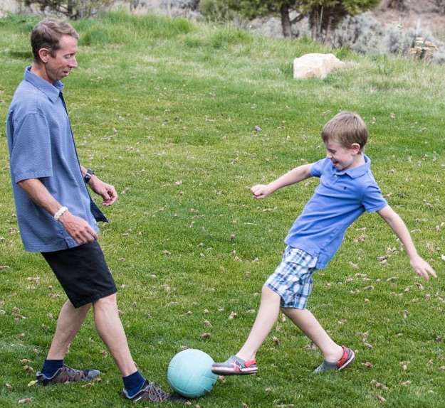 Father and son kicking a ball